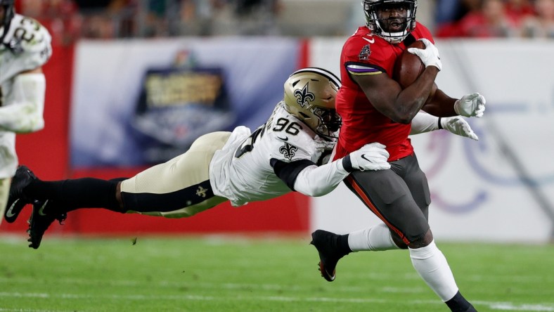 Dec 19, 2021; Tampa, Florida, USA;  Tampa Bay Buccaneers running back Leonard Fournette (7) is tackled by New Orleans Saints defensive end Carl Granderson (96) in the first quarter at Raymond James Stadium. Mandatory Credit: Nathan Ray Seebeck-USA TODAY Sports