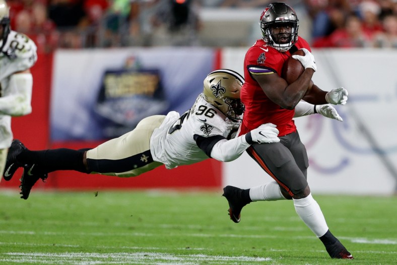 Dec 19, 2021; Tampa, Florida, USA;  Tampa Bay Buccaneers running back Leonard Fournette (7) is tackled by New Orleans Saints defensive end Carl Granderson (96) in the first quarter at Raymond James Stadium. Mandatory Credit: Nathan Ray Seebeck-USA TODAY Sports