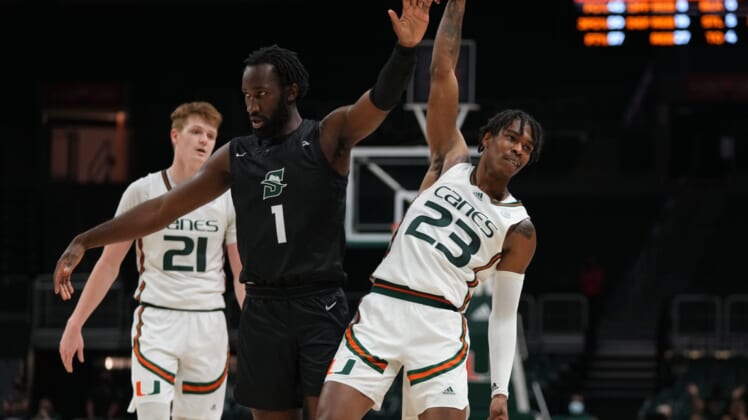Dec 20, 2021; Coral Gables, Florida, USA; Miami Hurricanes guard Kameron McGusty (23) reacts after making a three point shot over Stetson Hatters guard Wheza Panzo (1) during the second half at Watsco Center. Mandatory Credit: Jasen Vinlove-USA TODAY Sports