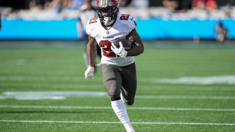 Dec 26, 2021; Charlotte, North Carolina, USA; Tampa Bay Buccaneers running back Ke'Shawn Vaughn (21) runs for a touchdown against the Carolina Panthers during the first quarter at Bank of America Stadium. Mandatory Credit: Jim Dedmon-USA TODAY Sports