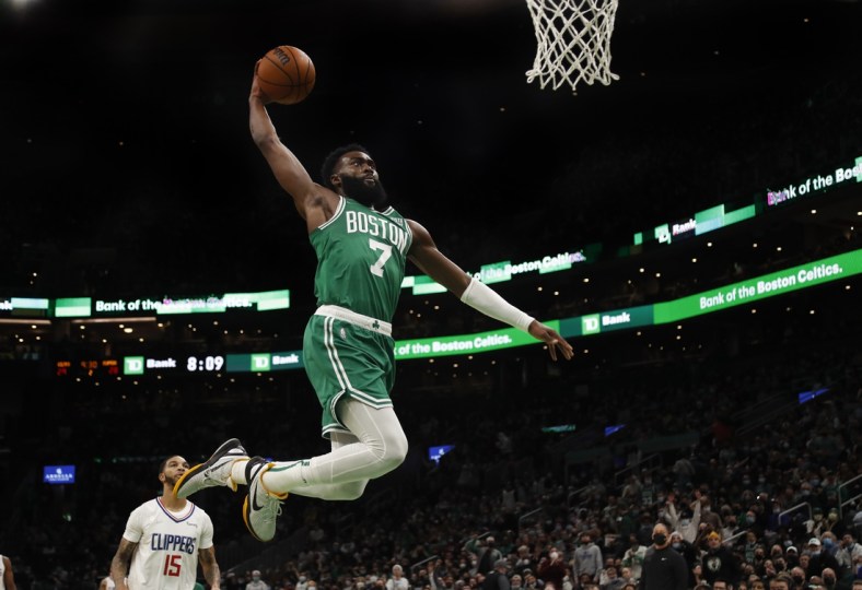 Dec 29, 2021; Boston, Massachusetts, USA; Boston Celtics guard Jaylen Brown (7) goes in for a dunk as LA Clippers guard Xavier Moon (15) looks on during the second quarter at TD Garden. Mandatory Credit: Winslow Townson-USA TODAY Sports
