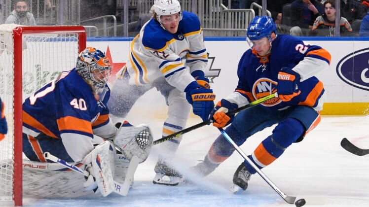 Dec 30, 2021; Elmont, New York, USA; Buffalo Sabres right wing Tage Thompson (72) and New York Islanders defenseman Scott Mayfield (24) scramble for the puck after a save by New York Islanders goaltender Semyon Varlamov (40) during the first period at UBS Arena. Mandatory Credit: Dennis Schneidler-USA TODAY Sports