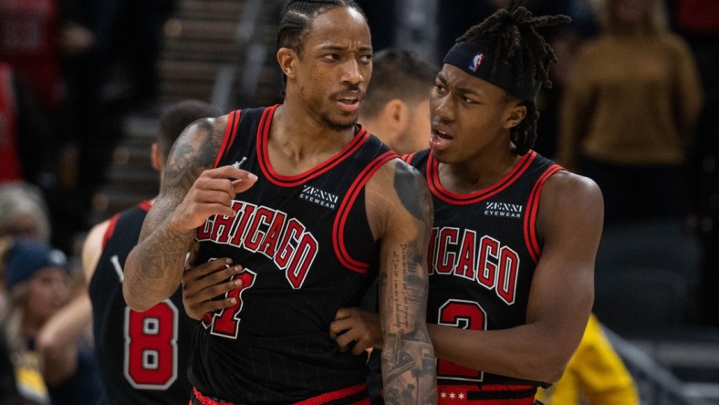 Dec 31, 2021; Indianapolis, Indiana, USA; Chicago Bulls forward DeMar DeRozan (11) is held back by Chicago Bulls guard Ayo Dosunmu (12) in the second half against the Indiana Pacers at Gainbridge Fieldhouse. Mandatory Credit: Trevor Ruszkowski-USA TODAY Sports