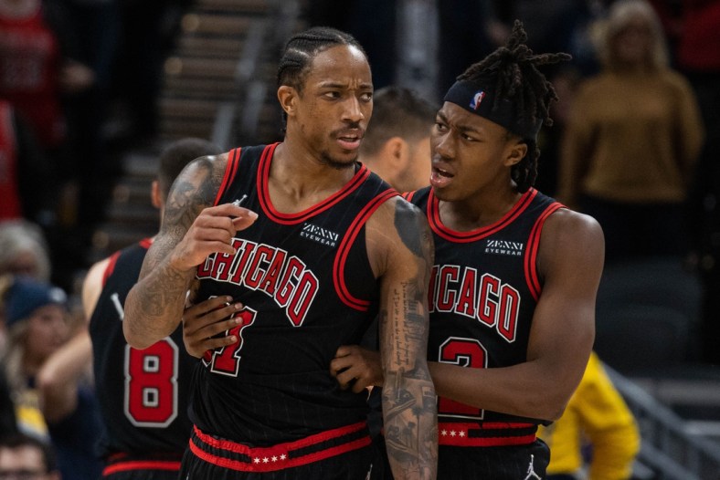 Dec 31, 2021; Indianapolis, Indiana, USA; Chicago Bulls forward DeMar DeRozan (11) is held back by Chicago Bulls guard Ayo Dosunmu (12) in the second half against the Indiana Pacers at Gainbridge Fieldhouse. Mandatory Credit: Trevor Ruszkowski-USA TODAY Sports