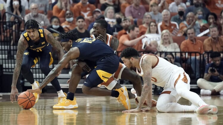 Jan 1, 2022; Austin, Texas, USA; West Virginia Mountaineers forward Jalen Bridges (11) and guard Malik Curry (10) battle for the loose ball along with Texas Longhorns forward Timmy Allen (0) during the first half at Frank C. Erwin Jr. Center. Mandatory Credit: Scott Wachter-USA TODAY Sports