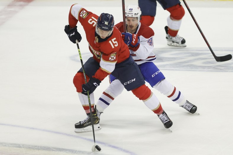 Jan 1, 2022; Sunrise, Florida, USA; Florida Panthers center Anton Lundell (15) moves the puck ahead of Montreal Canadiens left wing Rafael Harvey-Pinard (49) during the third period at FLA Live Arena. Mandatory Credit: Sam Navarro-USA TODAY Sports