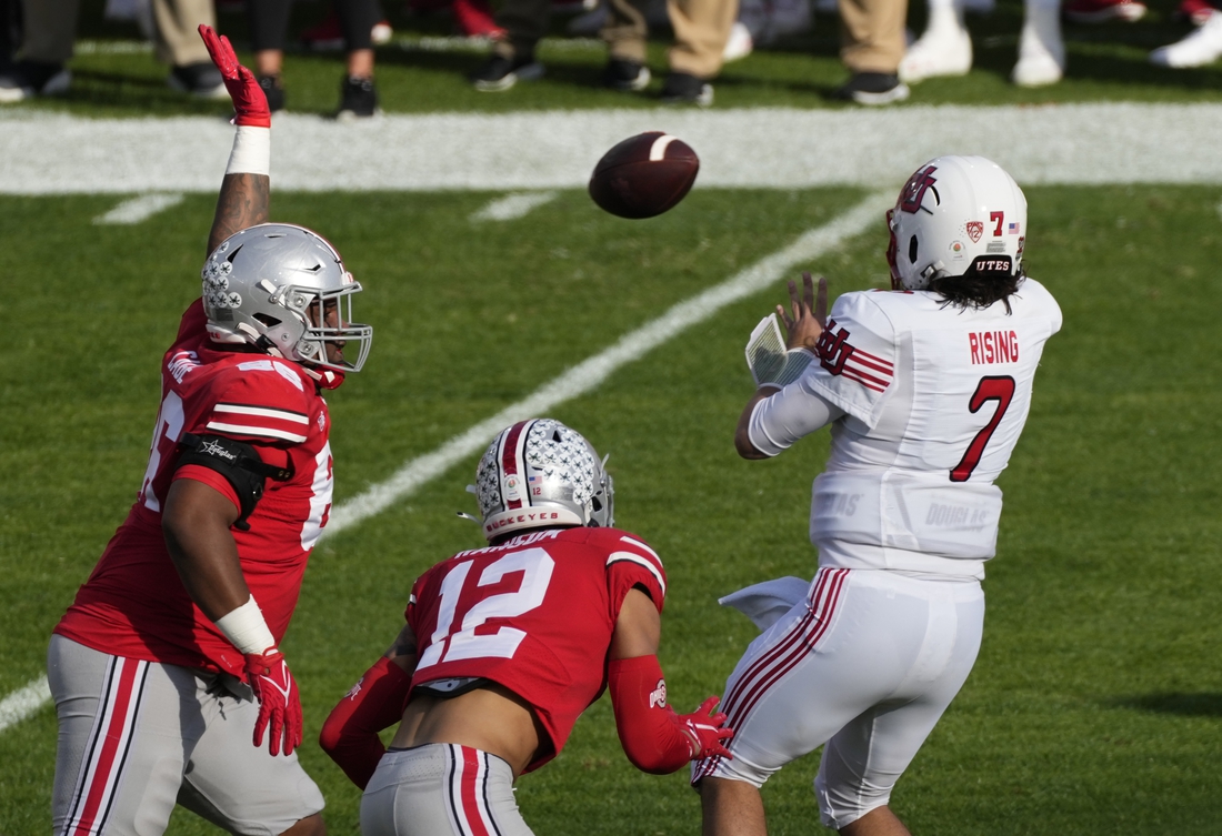 Jan 1, 2022; Pasadena, California, USA; Utah Utes quarterback Cameron Rising (7) gets off a pass pressured by Ohio State Buckeyes defensive tackle Jerron Cage (86) and Ohio State Buckeyes safety Lathan Ransom (12) during the first quarter of the 2022 Rose Bowl at Rose Bowl. Mandatory Credit: Robert Hanashiro-USA TODAY Sports