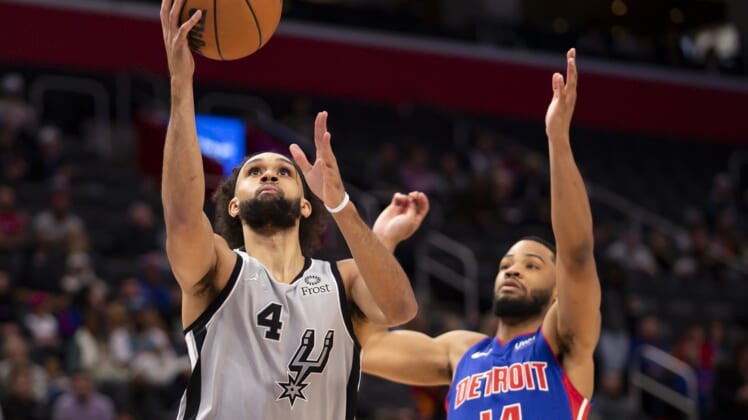 Jan 1, 2022; Detroit, Michigan, USA; San Antonio Spurs guard Derrick White (4) goes up for a shot against Detroit Pistons guard Cassius Stanley (14) during the first quarter at Little Caesars Arena. Mandatory Credit: Raj Mehta-USA TODAY Sports