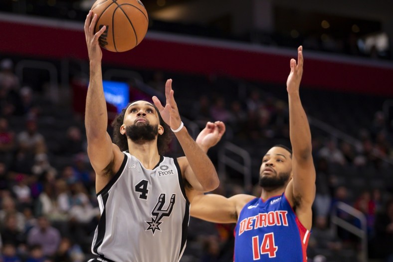 Jan 1, 2022; Detroit, Michigan, USA; San Antonio Spurs guard Derrick White (4) goes up for a shot against Detroit Pistons guard Cassius Stanley (14) during the first quarter at Little Caesars Arena. Mandatory Credit: Raj Mehta-USA TODAY Sports