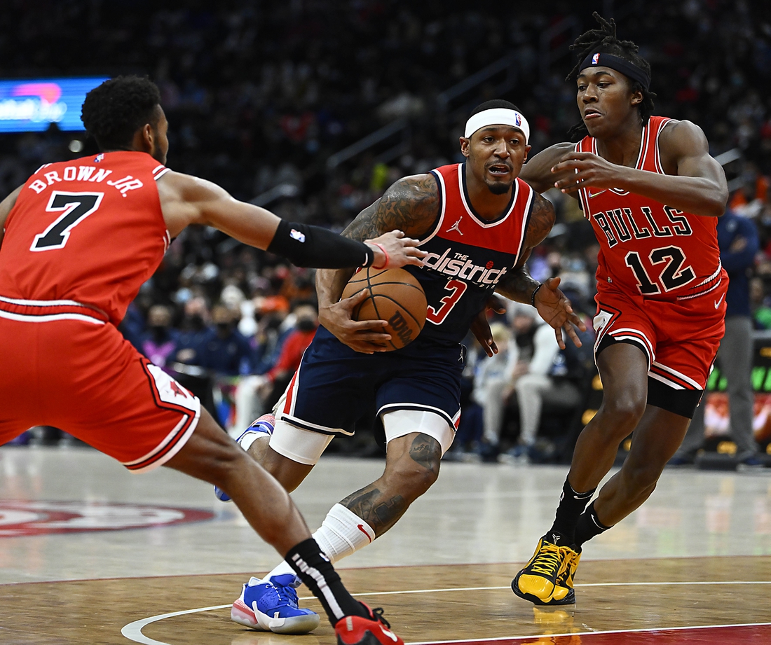 Jan 1, 2022; Washington, District of Columbia, USA; Washington Wizards guard Bradley Beal (3) drives between Chicago Bulls forward Troy Brown Jr. (7) and guard Ayo Dosunmu (12) during the first half at Capital One Arena. Mandatory Credit: Brad Mills-USA TODAY Sports