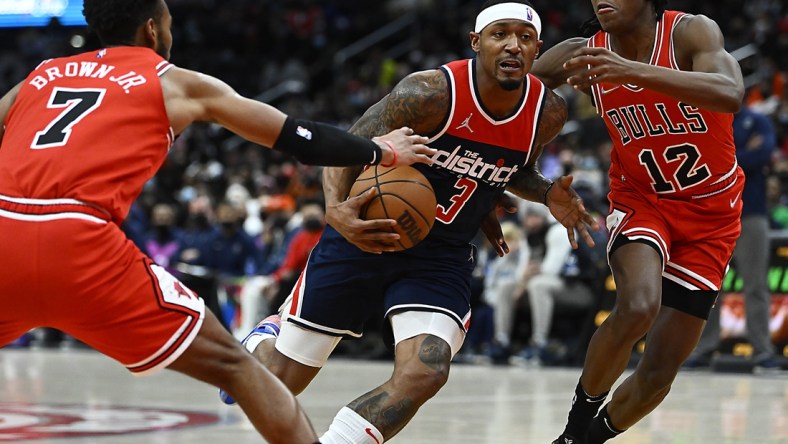 Jan 1, 2022; Washington, District of Columbia, USA; Washington Wizards guard Bradley Beal (3) drives between Chicago Bulls forward Troy Brown Jr. (7) and guard Ayo Dosunmu (12) during the first half at Capital One Arena. Mandatory Credit: Brad Mills-USA TODAY Sports