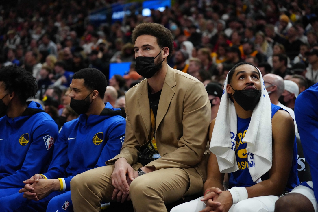 Jan 1, 2022; Salt Lake City, Utah, USA; Golden State Warriors guard Klay Thompson (11) (center) on the bench in the first half against the Utah Jazz at Vivint Arena. Mandatory Credit: Ron Chenoy-USA TODAY Sports