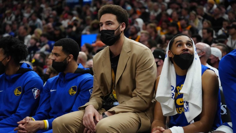 Jan 1, 2022; Salt Lake City, Utah, USA; Golden State Warriors guard Klay Thompson (11) (center) on the bench in the first half against the Utah Jazz at Vivint Arena. Mandatory Credit: Ron Chenoy-USA TODAY Sports