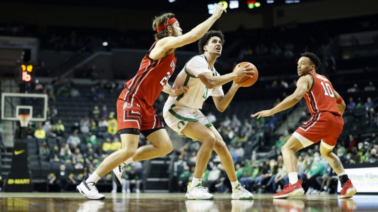 Jan 1, 2022; Eugene, Oregon, USA; Oregon Ducks guard Will Richardson (0) drives to the basket while guarded by Utah Utes guard Rollie Worster (25) (left) during the first half at Matthew Knight Arena. Mandatory Credit: Soobum Im-USA TODAY Sports