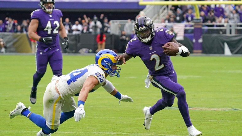 Jan 2, 2022; Baltimore, Maryland, USA; Baltimore Ravens quarterback Tyler Huntley (2) runs for a gain in the second quarter defended by Los Angeles Rams safety Taylor Rapp (24) at M&T Bank Stadium. Mandatory Credit: Mitch Stringer-USA TODAY Sports