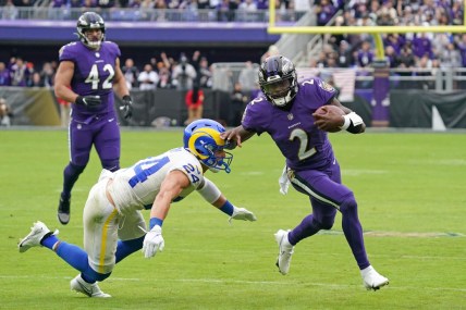 Jan 2, 2022; Baltimore, Maryland, USA; Baltimore Ravens quarterback Tyler Huntley (2) runs for a gain in the second quarter defended by Los Angeles Rams safety Taylor Rapp (24) at M&T Bank Stadium. Mandatory Credit: Mitch Stringer-USA TODAY Sports