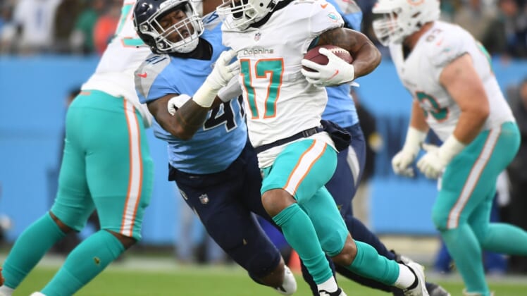Jan 2, 2022; Nashville, Tennessee, USA; Miami Dolphins wide receiver Jaylen Waddle (17) fights off a tackle attempt from Tennessee Titans outside linebacker Zach Cunningham (41) during the first half at Nissan Stadium. Mandatory Credit: Christopher Hanewinckel-USA TODAY Sports