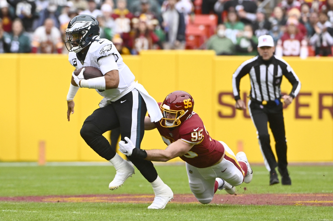 Jan 2, 2022; Landover, Maryland, USA; Philadelphia Eagles quarterback Jalen Hurts (1) scrambles as Washington Football Team defensive end Casey Toohill (95) defends during the first half at FedExField. Mandatory Credit: Brad Mills-USA TODAY Sports