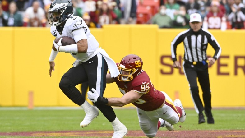 Jan 2, 2022; Landover, Maryland, USA; Philadelphia Eagles quarterback Jalen Hurts (1) scrambles as Washington Football Team defensive end Casey Toohill (95) defends during the first half at FedExField. Mandatory Credit: Brad Mills-USA TODAY Sports