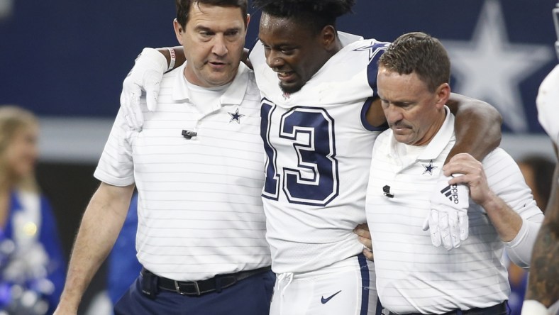 Jan 2, 2022; Arlington, Texas, USA; Dallas Cowboys wide receiver Michael Gallup (13) is helped off the field after an injury in the second quarter against the Arizona Cardinals at AT&T Stadium. Mandatory Credit: Tim Heitman-USA TODAY Sports