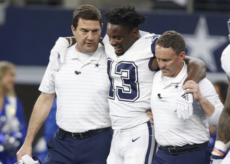 Jan 2, 2022; Arlington, Texas, USA; Dallas Cowboys wide receiver Michael Gallup (13) is helped off the field after an injury in the second quarter against the Arizona Cardinals at AT&T Stadium. Mandatory Credit: Tim Heitman-USA TODAY Sports