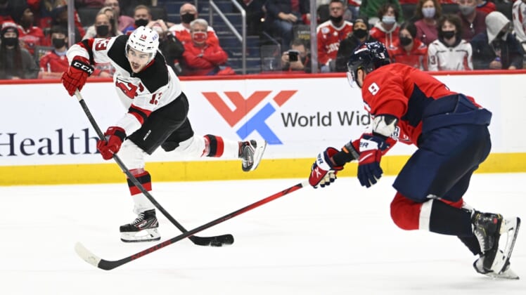 Jan 2, 2022; Washington, District of Columbia, USA; New Jersey Devils center Nico Hischier (13) scores the game winning goal as Washington Capitals defenseman Dmitry Orlov (9) defends during the overtime period at Capital One Arena. Mandatory Credit: Brad Mills-USA TODAY Sports