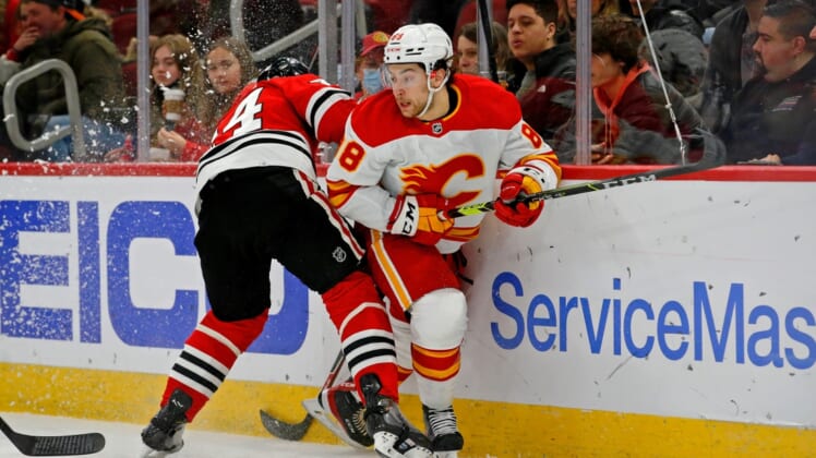 Jan 2, 2022; Chicago, Illinois, USA; Chicago Blackhawks defenseman Calvin de Haan (44) checks Calgary Flames left wing Andrew Mangiapane (88)  during the first period at United Center. Mandatory Credit: Jon Durr-USA TODAY Sports