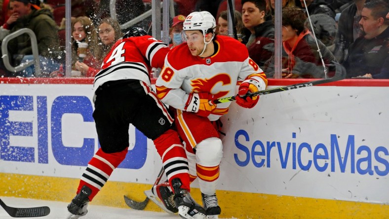 Jan 2, 2022; Chicago, Illinois, USA; Chicago Blackhawks defenseman Calvin de Haan (44) checks Calgary Flames left wing Andrew Mangiapane (88)  during the first period at United Center. Mandatory Credit: Jon Durr-USA TODAY Sports