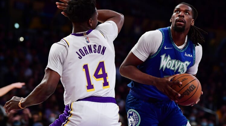 Jan 2, 2022; Los Angeles, California, USA; Minnesota Timberwolves center Naz Reid (11) moves to the basket against Los Angeles Lakers forward Stanley Johnson (14) during the first half at Crypto.com Arena. Mandatory Credit: Gary A. Vasquez-USA TODAY Sports