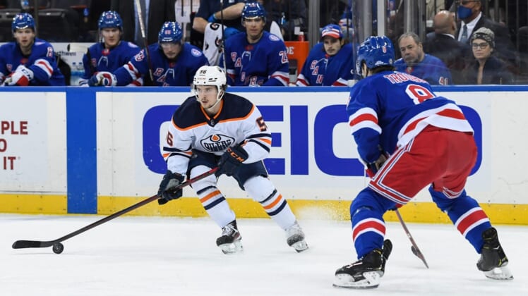 Jan 3, 2022; New York, New York, USA; Edmonton Oilers right wing Kailer Yamamoto (56) controls the puck defended by New York Rangers defenseman Jacob Trouba (8) during the first period at Madison Square Garden. Mandatory Credit: Dennis Schneidler-USA TODAY Sports
