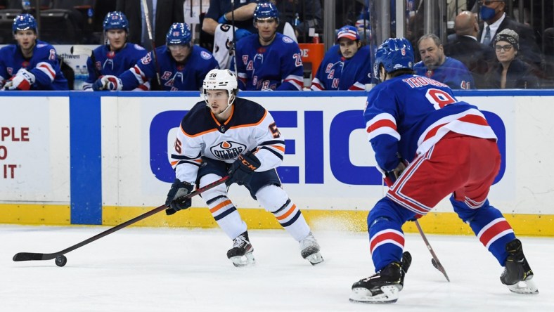 Jan 3, 2022; New York, New York, USA; Edmonton Oilers right wing Kailer Yamamoto (56) controls the puck defended by New York Rangers defenseman Jacob Trouba (8) during the first period at Madison Square Garden. Mandatory Credit: Dennis Schneidler-USA TODAY Sports