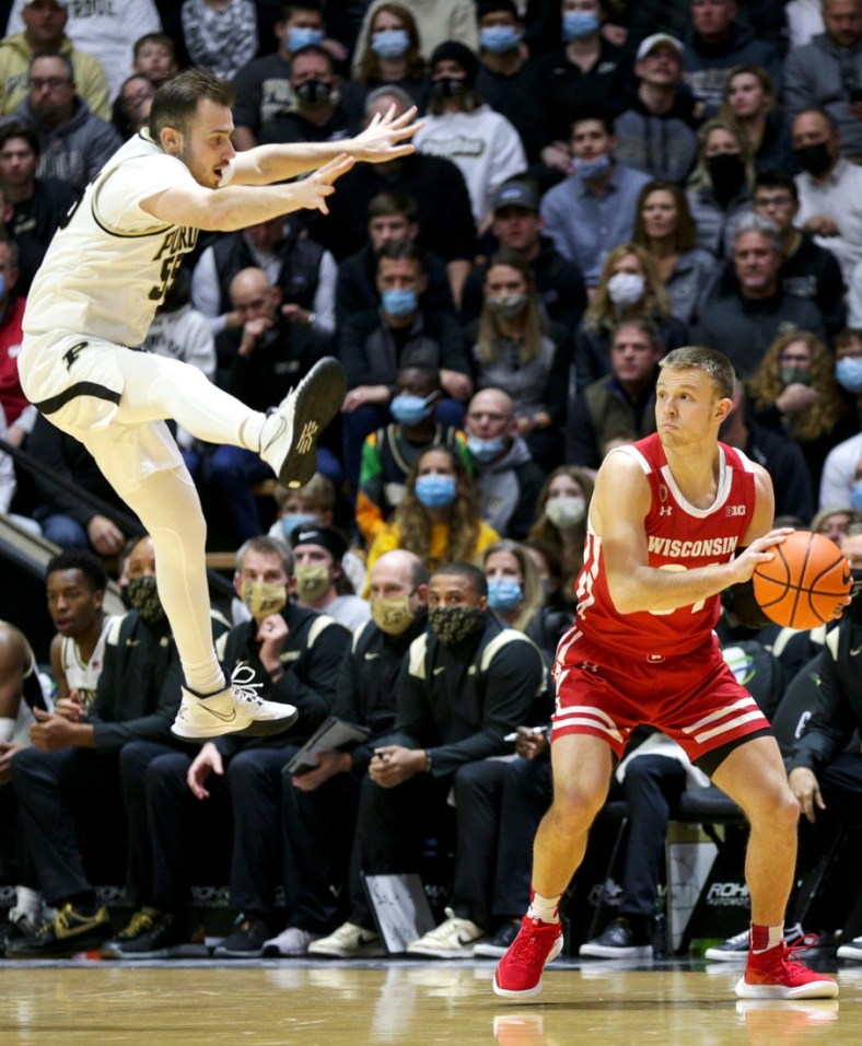 Wisconsin guard Brad Davison (34) looks to pass the ball as Purdue guard Sasha Stefanovic (55) flies through the air after jumping to block an attempted pass during the first half of an NCAA men's basketball game, Monday, Jan. 3, 2022 at Mackey Arena in West Lafayette.

Bkc Purdue Vs Wisconsin