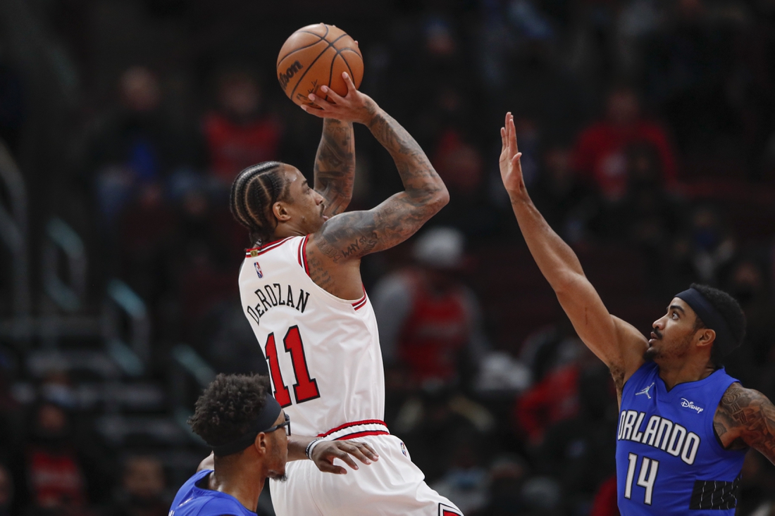 Jan 3, 2022; Chicago, Illinois, USA; Chicago Bulls forward DeMar DeRozan (11) shoots against Orlando Magic guard Gary Harris (14) during the first half at United Center. Mandatory Credit: Kamil Krzaczynski-USA TODAY Sports