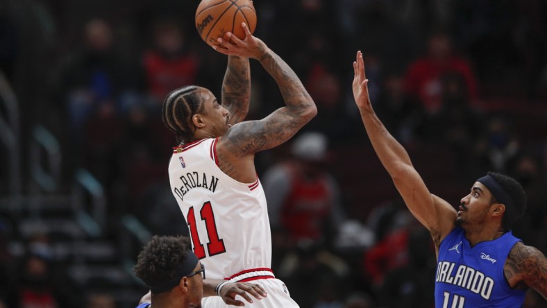 Jan 3, 2022; Chicago, Illinois, USA; Chicago Bulls forward DeMar DeRozan (11) shoots against Orlando Magic guard Gary Harris (14) during the first half at United Center. Mandatory Credit: Kamil Krzaczynski-USA TODAY Sports