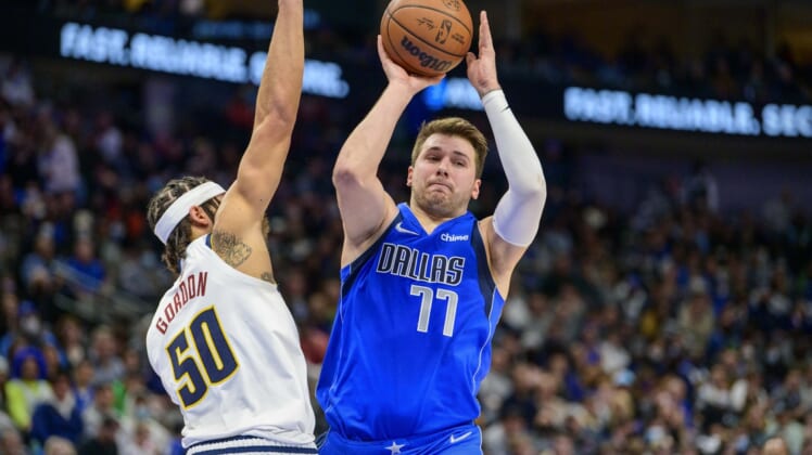 Jan 3, 2022; Dallas, Texas, USA; Dallas Mavericks guard Luka Doncic (77) passes the ball by Denver Nuggets forward Aaron Gordon (50) during the second quarter at the American Airlines Center. Mandatory Credit: Jerome Miron-USA TODAY Sports