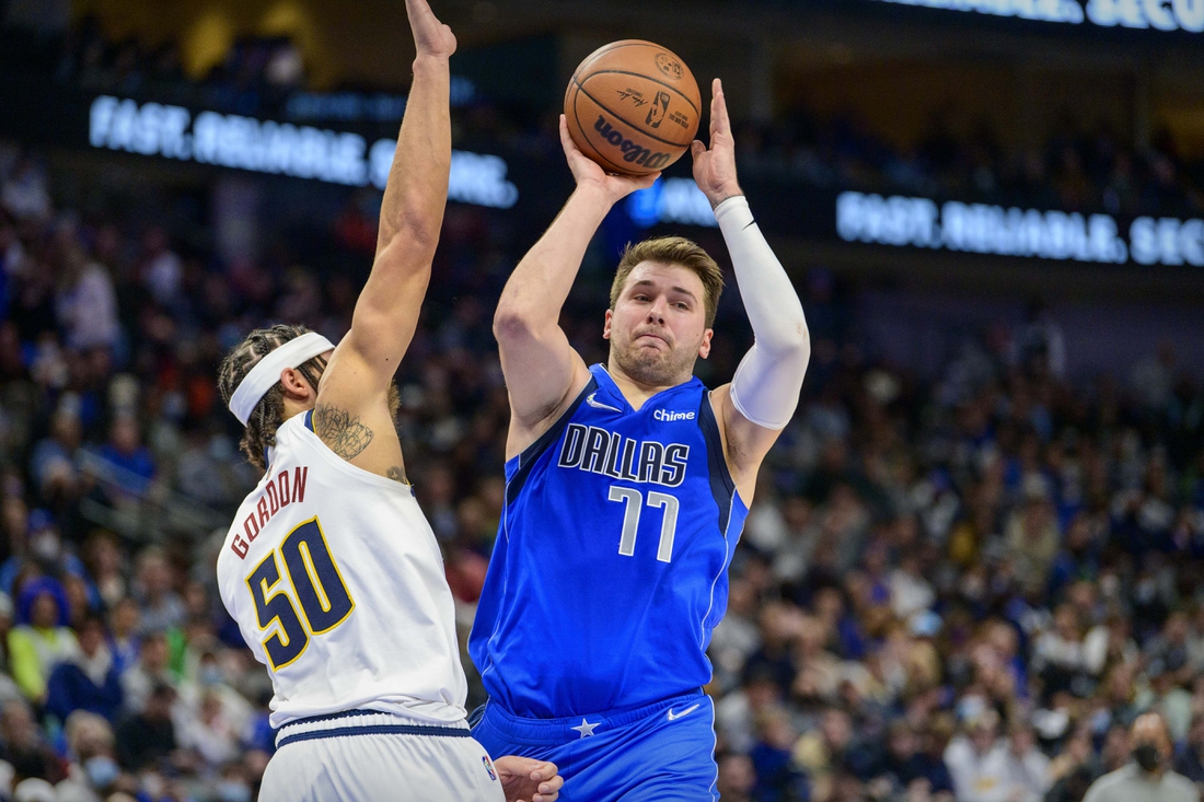 Jan 3, 2022; Dallas, Texas, USA; Dallas Mavericks guard Luka Doncic (77) passes the ball by Denver Nuggets forward Aaron Gordon (50) during the second quarter at the American Airlines Center. Mandatory Credit: Jerome Miron-USA TODAY Sports