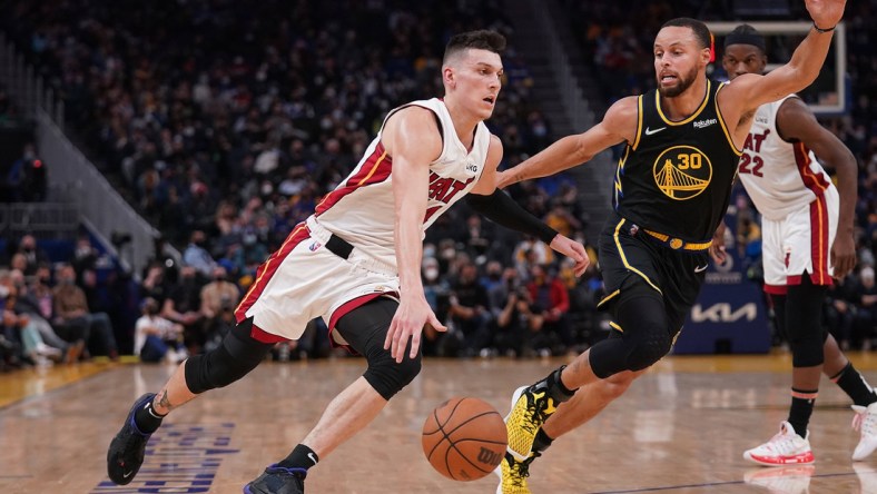 Jan 3, 2022; San Francisco, California, USA; Miami Heat guard Tyler Herro (14) dribbles past Golden State Warriors guard Stephen Curry (30) in the second quarter at the Chase Center. Mandatory Credit: Cary Edmondson-USA TODAY Sports