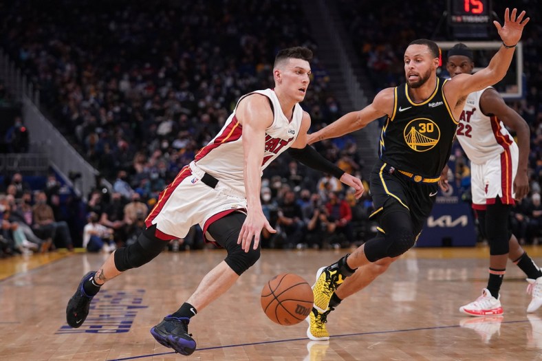 Jan 3, 2022; San Francisco, California, USA; Miami Heat guard Tyler Herro (14) dribbles past Golden State Warriors guard Stephen Curry (30) in the second quarter at the Chase Center. Mandatory Credit: Cary Edmondson-USA TODAY Sports