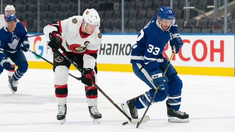 Jan 1, 2022; Toronto, Ontario, CAN; Toronto Maple Leafs defenceman Alex Biega (33) battles for the puck with Ottawa Senators left wing Brady Tkachuk (7) during the second period at Scotiabank Arena. Mandatory Credit: Nick Turchiaro-USA TODAY Sports