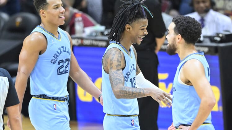 Jan 4, 2022; Cleveland, Ohio, USA; Memphis Grizzlies guard Desmond Bane (22) and guard Ja Morant (12) and Memphis Grizzlies guard Tyus Jones (21) celebrate in the fourth quarter against the Cleveland Cavaliers at Rocket Mortgage FieldHouse. Mandatory Credit: David Richard-USA TODAY Sports