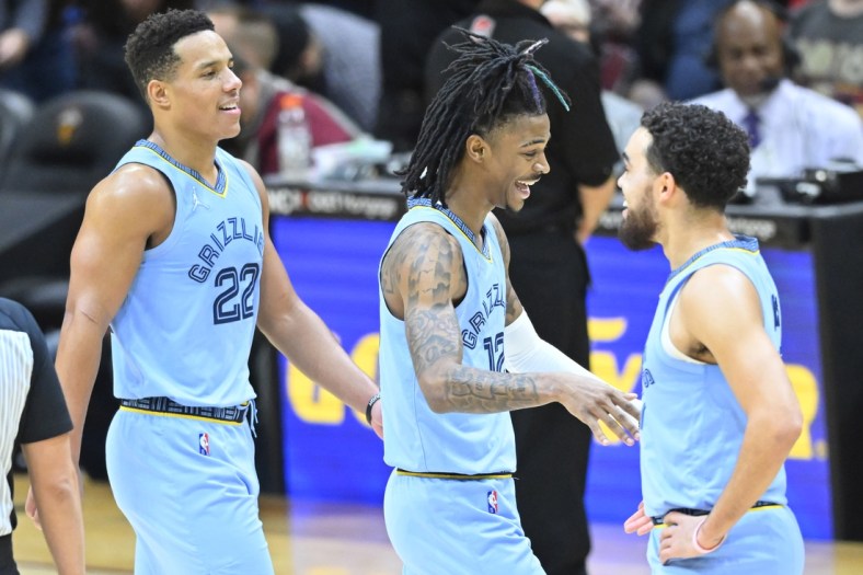 Jan 4, 2022; Cleveland, Ohio, USA; Memphis Grizzlies guard Desmond Bane (22) and guard Ja Morant (12) and Memphis Grizzlies guard Tyus Jones (21) celebrate in the fourth quarter against the Cleveland Cavaliers at Rocket Mortgage FieldHouse. Mandatory Credit: David Richard-USA TODAY Sports