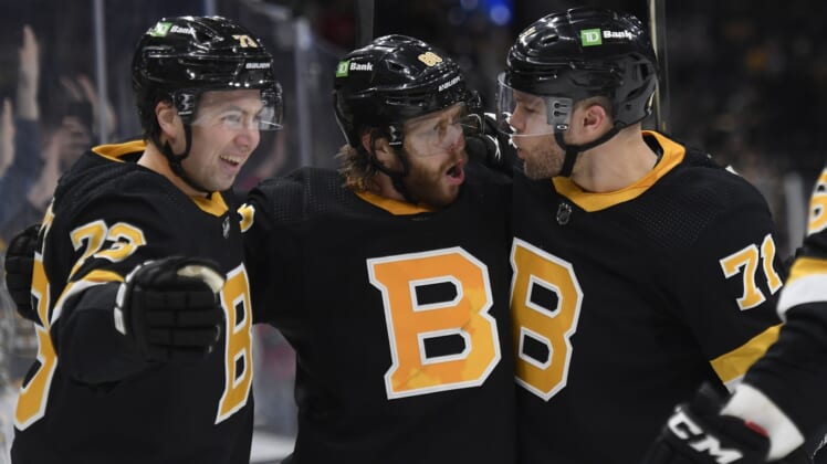 Jan 4, 2022; Boston, Massachusetts, USA;  Boston Bruins right wing David Pastrnak (88) reacts with defenseman Charlie McAvoy (73) and left wing Taylor Hall (71) after scoring a goal during the third period against the New Jersey Devils at TD Garden. Mandatory Credit: Bob DeChiara-USA TODAY Sports