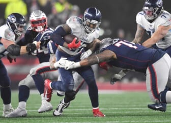 Tennessee Titans running back Derrick Henry (22) runs through the New England Patriots defense during the AFC Wild Card game at Gillette Stadium in Foxborough, Mass., Jan. 4, 2020.

Gw55073