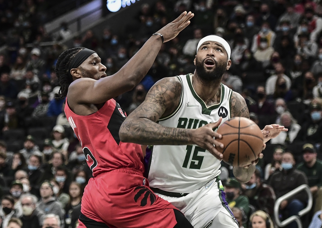 Jan 5, 2022; Milwaukee, Wisconsin, USA; Milwaukee Bucks center DeMarcus Cousins (15) looks for a shot against Toronto Raptors forward Precious Achiuwa (5) in the second quarter at Fiserv Forum. Mandatory Credit: Benny Sieu-USA TODAY Sports