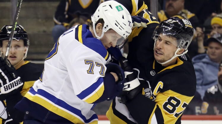 Jan 5, 2022; Pittsburgh, Pennsylvania, USA;  St. Louis Blues defenseman Niko Mikkola (77) and Pittsburgh Penguins center Sidney Crosby (87) exchange punches during the second period at PPG Paints Arena. Mandatory Credit: Charles LeClaire-USA TODAY Sports