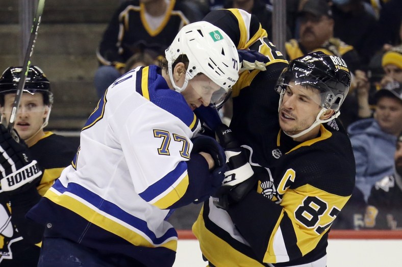 Jan 5, 2022; Pittsburgh, Pennsylvania, USA;  St. Louis Blues defenseman Niko Mikkola (77) and Pittsburgh Penguins center Sidney Crosby (87) exchange punches during the second period at PPG Paints Arena. Mandatory Credit: Charles LeClaire-USA TODAY Sports