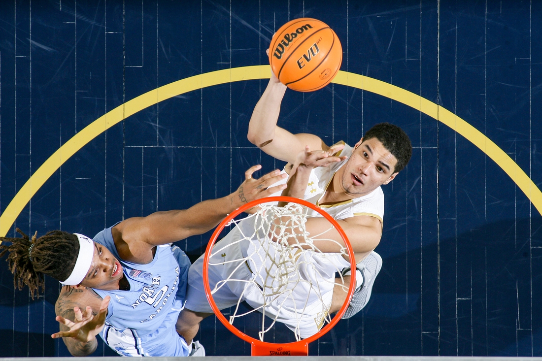 Jan 5, 2022; South Bend, Indiana, USA; Notre Dame Fighting Irish forward Paul Atkinson Jr. (20) shoots as North Carolina Tar Heels forward Armando Bacot (5) defends in the second half at the Purcell Pavilion. Mandatory Credit: Matt Cashore-USA TODAY Sports