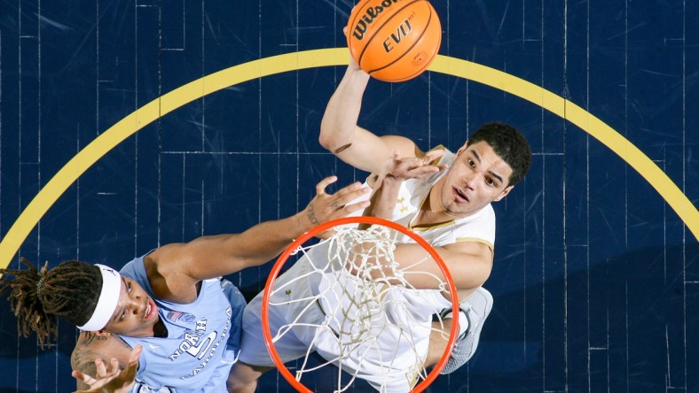 Jan 5, 2022; South Bend, Indiana, USA; Notre Dame Fighting Irish forward Paul Atkinson Jr. (20) shoots as North Carolina Tar Heels forward Armando Bacot (5) defends in the second half at the Purcell Pavilion. Mandatory Credit: Matt Cashore-USA TODAY Sports