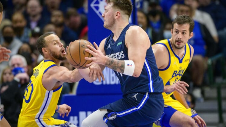 Jan 5, 2022; Dallas, Texas, USA; Dallas Mavericks guard Luka Doncic (77) is fouled by Golden State Warriors guard Stephen Curry (30) during the game between the Dallas Mavericks and the Golden State Warriors at the American Airlines Center. Mandatory Credit: Jerome Miron-USA TODAY Sports