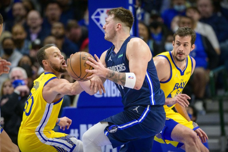 Jan 5, 2022; Dallas, Texas, USA; Dallas Mavericks guard Luka Doncic (77) is fouled by Golden State Warriors guard Stephen Curry (30) during the game between the Dallas Mavericks and the Golden State Warriors at the American Airlines Center. Mandatory Credit: Jerome Miron-USA TODAY Sports